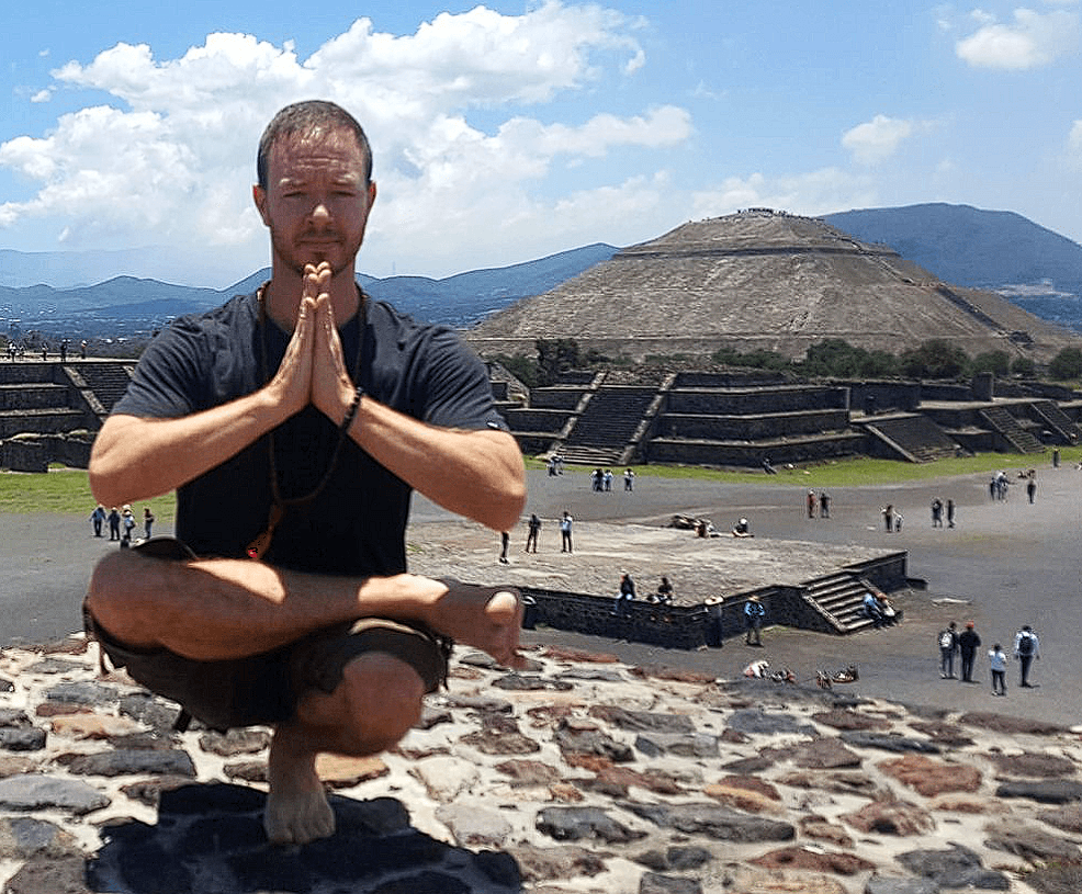 Yoga Teacher/Trainer Jai Salsbery E-RYT500 performing Toe Stand, Padangustasana, on top of a Pyramid at the Pyramids of Teotihuacan